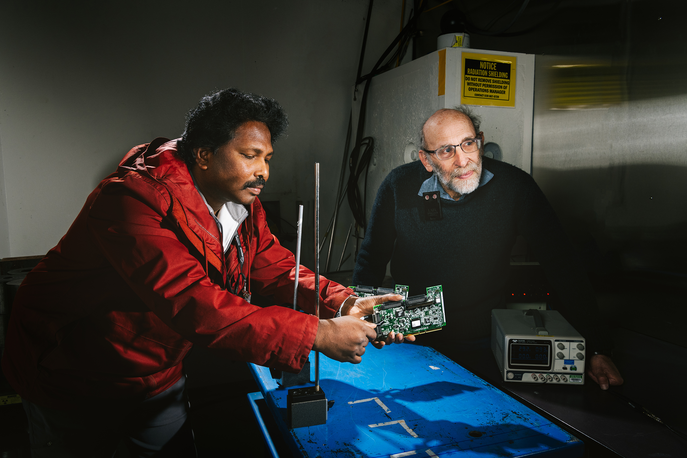 Kranti Gunthoti and Steve Wender adjust a circuit board in the neutron beam path.