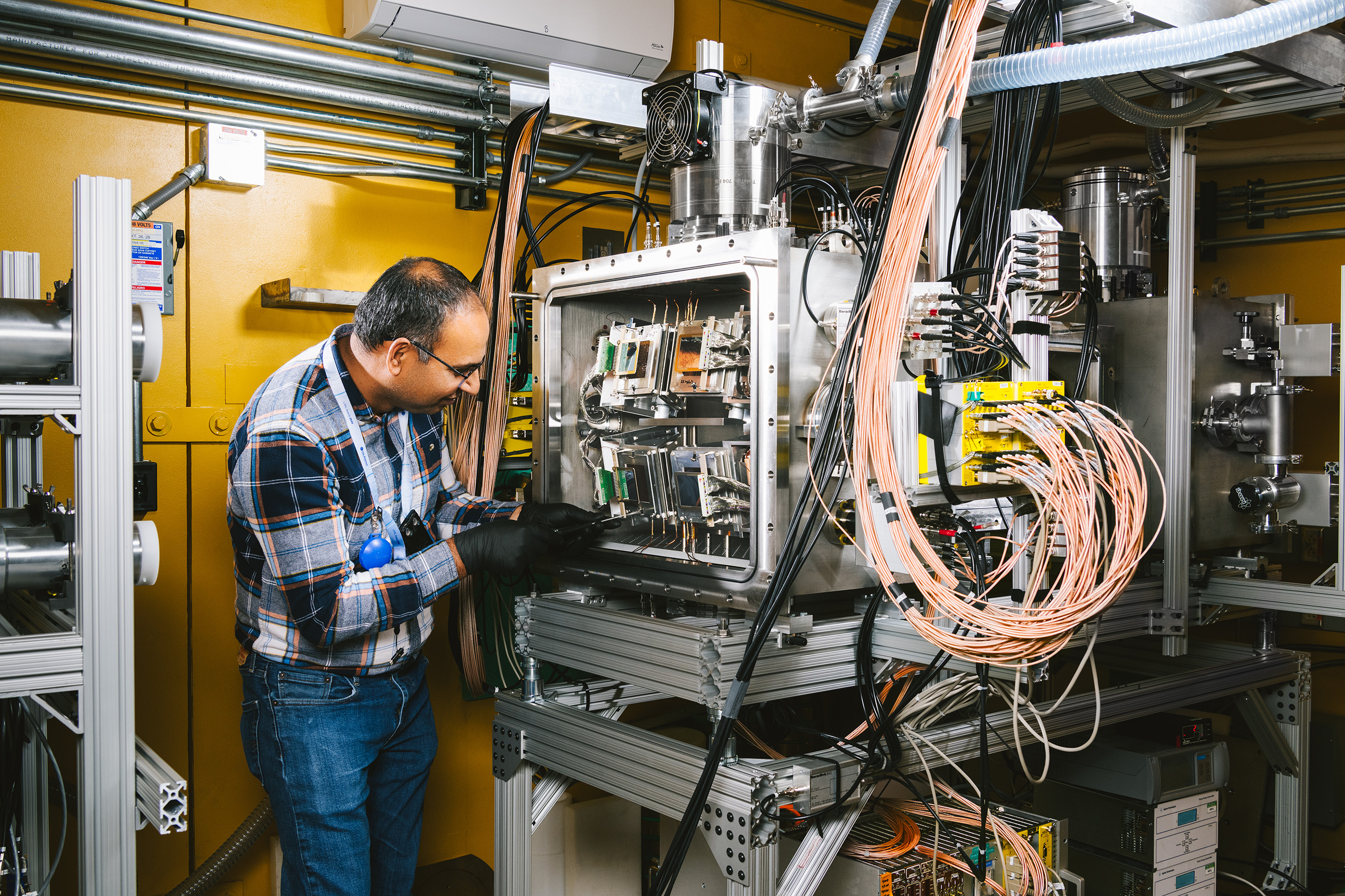 A scientist adjusts a component in SPIDER.