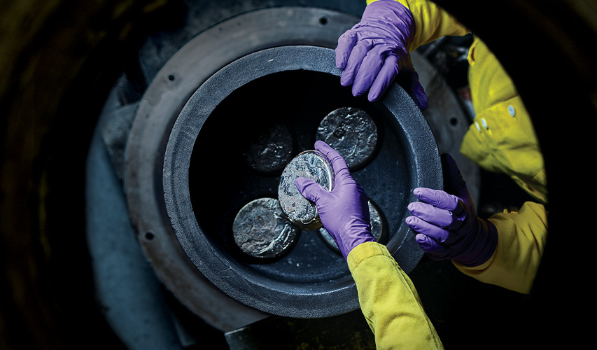 Uranium alloy pucks are placed into a vacuum furnace at Los Alamos National Laboratory’s Sigma Complex.
